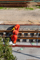 Tel Aviv, Israel - May 20 2021: Construction Workers with Orange overalls. Light rail tracks. blue...