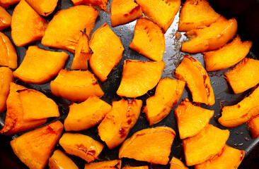 Pieces of pumpkin baked on a baking sheet. Food