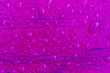 Abstract pattern of water droplets on a purple painted wooden surface after rain . Top view. Abstract background and texture for design.