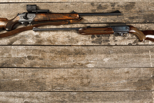 Hunting weapon on dark wooden backgorund, top view