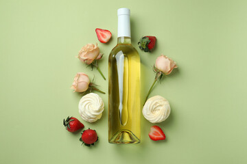 Sweet food and blank wine bottle on green background