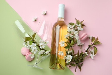 Wine, macaroons and flowers on two tone background