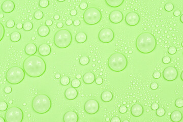 Water drops on green background texture. Backdrop glass covered with drops of water. green bubbles...