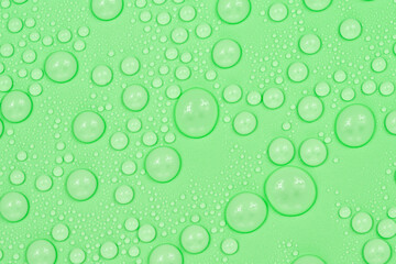 Water drops on green background texture. Backdrop glass covered with drops of water. green bubbles in water.