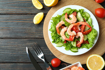 Concept of tasty eating with shrimp salad on wooden table
