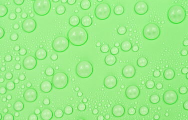 Water drops on green background texture. Backdrop glass covered with drops of water. green bubbles in water.