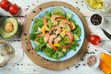 Concept of tasty eating with shrimp salad on white wooden table