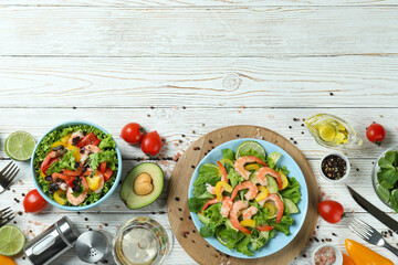 Concept of tasty eating with shrimp salad on white wooden table