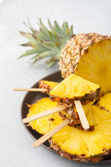 Ripe juicy pineapple cut into rings close-up, pineapple in the form of ice cream on a stick