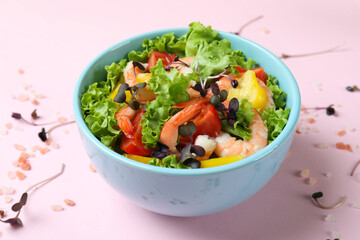 Concept of tasty eating with shrimp salad on pink background