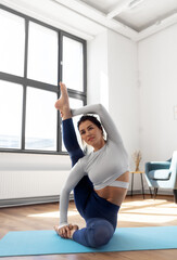 fitness, people and healthy lifestyle concept - young woman doing yoga at studio