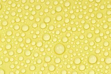 Water drops on yellow background texture. Backdrop glass covered with drops of water. yellow bubbles in water. beer texture