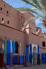 sale of traditional bright colored textiles and fabrics on the street of magnificent old kasbah in Atlas mountains of Morocco