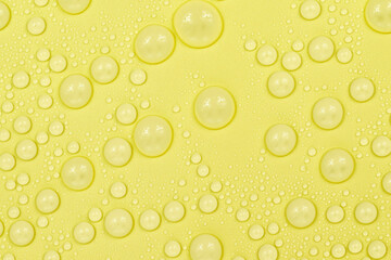 Water drops on yellow background texture. Backdrop glass covered with drops of water. yellow bubbles in water. beer texture