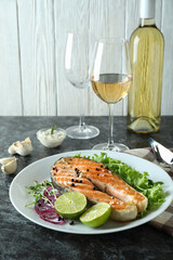 Concept of tasty eating with grilled salmon on black smokey table