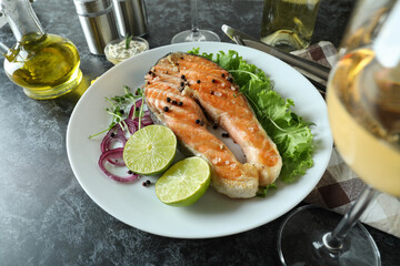 Concept of tasty eating with grilled salmon on black smokey table