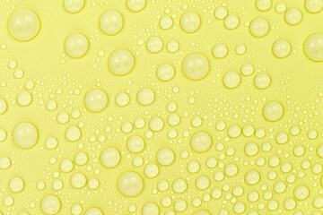 Water drops on yellow background texture. Backdrop glass covered with drops of water. yellow bubbles in water. beer texture