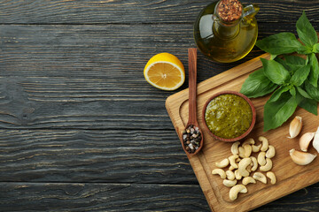 Fototapeta na wymiar Pesto sauce and ingredients for cooking on wooden background