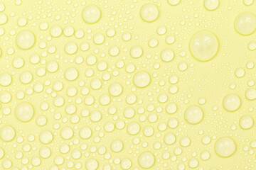 Water drops on yellow background texture. Backdrop glass covered with drops of water. yellow bubbles in water. beer texture