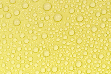 Water drops on yellow background texture. Backdrop glass covered with drops of water. yellow bubbles in water. beer texture