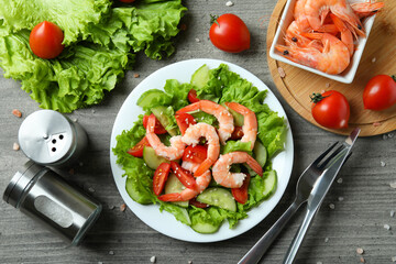 Concept of tasty eating with shrimp salad on gray wooden table