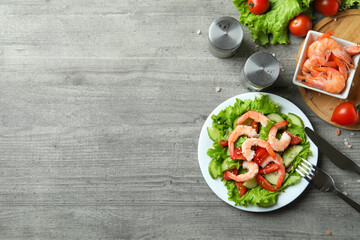 Concept of tasty eating with shrimp salad on gray wooden table