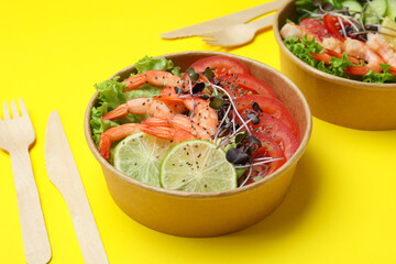 Concept of tasty eating with shrimp salads on yellow background