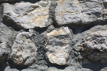 Natural stones filled up with cement or wall with quarry stones dark plastered, texture, concept for landscaping and garden design, close up