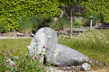 Garden design landscaping:A waterspout fountain with water sparkling out of a boulder in a hillside...