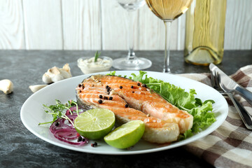 Concept of tasty eating with grilled salmon on black smokey table