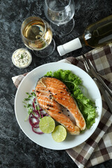 Concept of tasty eating with grilled salmon on black smokey table