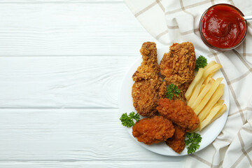 Concept of tasty eating with fried chicken on white wooden background