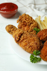 Concept of tasty eating with fried chicken on white wooden background