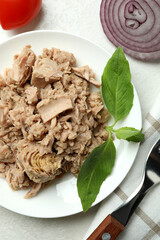 Concept of tasty eating with canned tuna on white textured background