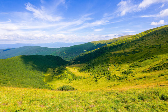 grass on the steep hill. view in to the distant valleys and Gorgany ridge beneath a blue sky with clouds. wonderful summer landscape on a sunny weather in carpathian mountains