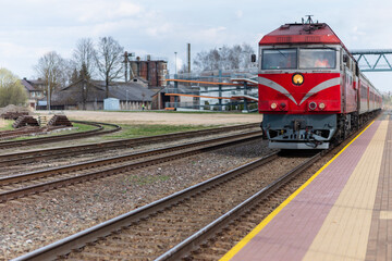 Fototapeta premium Railroad tracks and red locomotive in the town.old train locomotive.