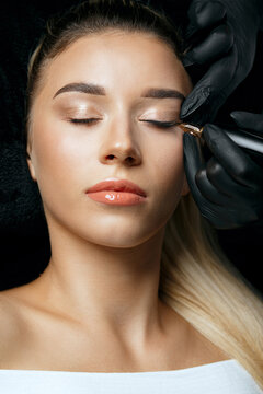 Makeup artist in gloves applying permanent makeup
