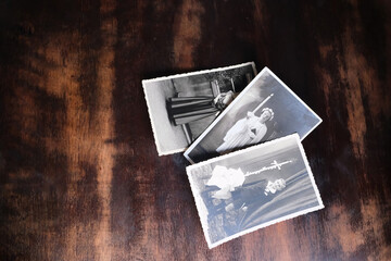 old vintage monochrome photographs of children 1940 - 1950 in sepia color are scattered on wooden...