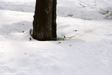 an empty vodka bottle is lying on the snow