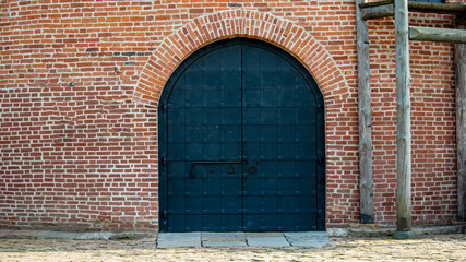 large iron door of a medieval defensive brick tower
