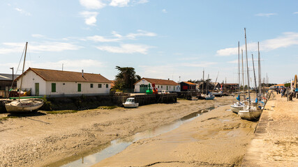 Fototapeta na wymiar Boats in the harbor in low tide in Noirmoutier in France