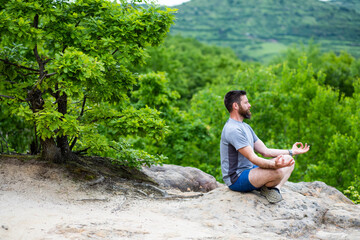 Naklejka na ściany i meble young man meditating outdoors