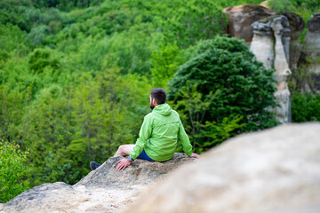 man with his dog sitting on a rock enjoying nature