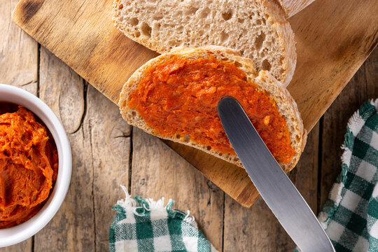 Sliced toast bread with sobrasada on rustic wooden table. Typical Mallorca food in Spain.	