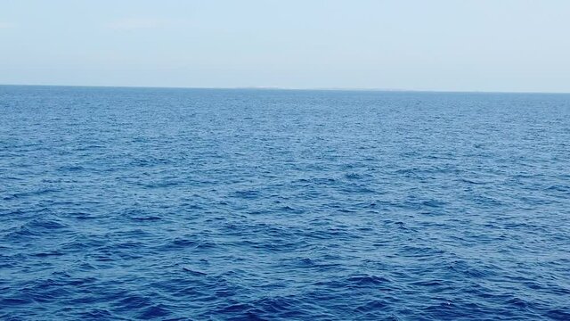 travelling avant en slow motion au dessus de la mer face &agrave; une ile &agrave; l'horizon
