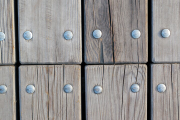 Wooden planks attached with metal bolts. Slots at the joints. Wooden background concept.