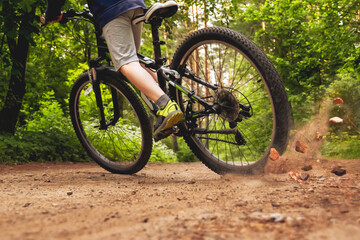 The skidded bicycle. Back view. Forest background blurred in motion.