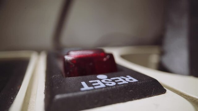 Young woman finger with shiny nail polish presses red button Reset to switch off contemporary network extension cord in room extreme closeup