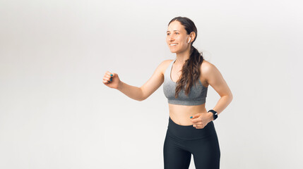 Photo of young sport woman running and listening music over white background