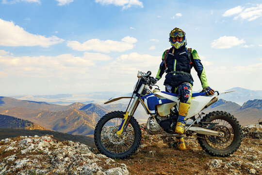 Man in sport equipment riding a motorcross bike in mountains